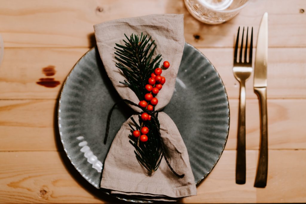 A bird's eye view of a Christmas dinner setting with plate, napkin and cutlery