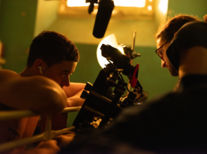 Camera man up close to inmate character with a camera