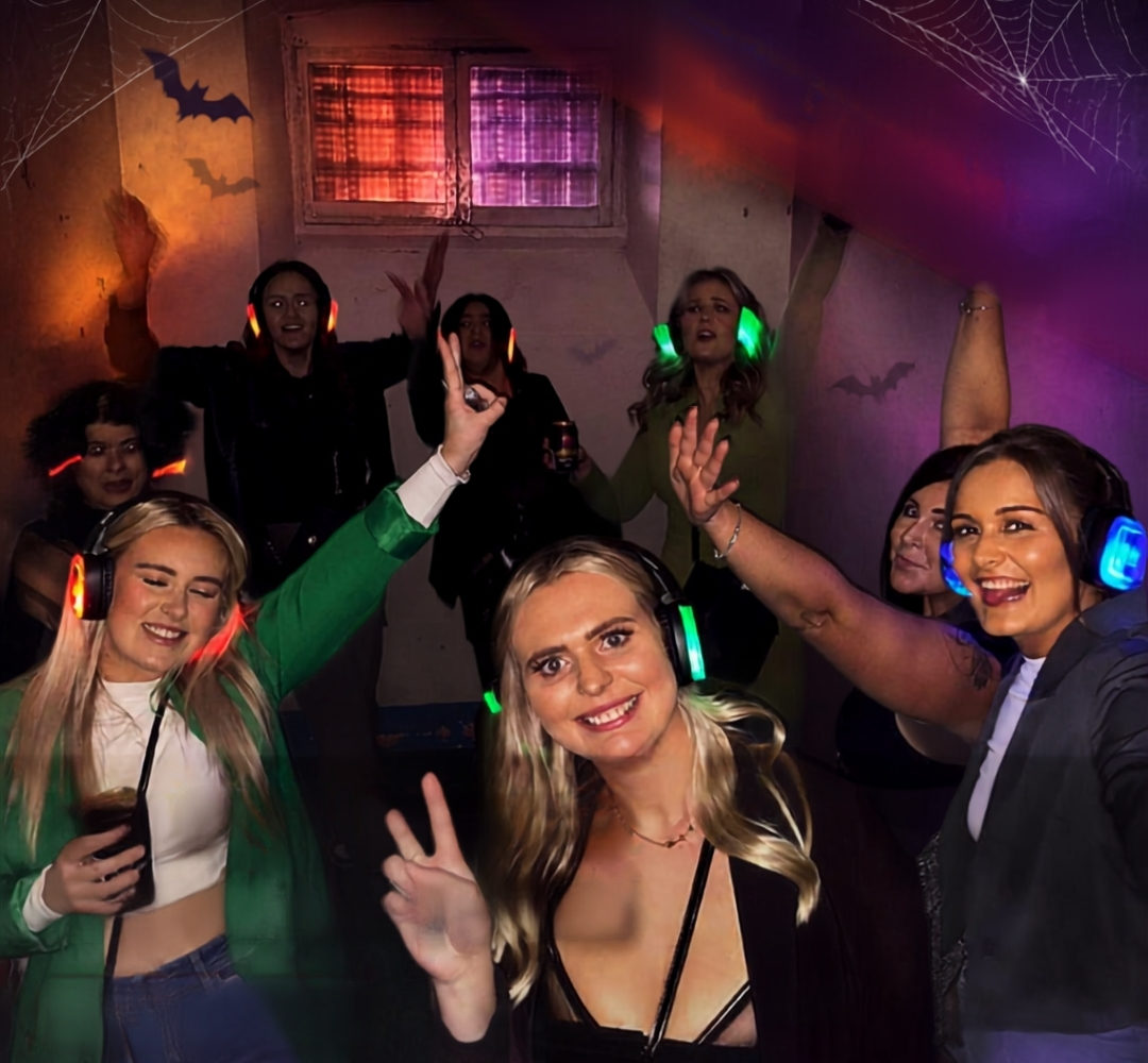 Friends in dancing inside a Shepton Mallet Prison cell during Halloween Silent Disco party